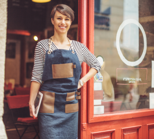 business owner standing at cafe with tablet