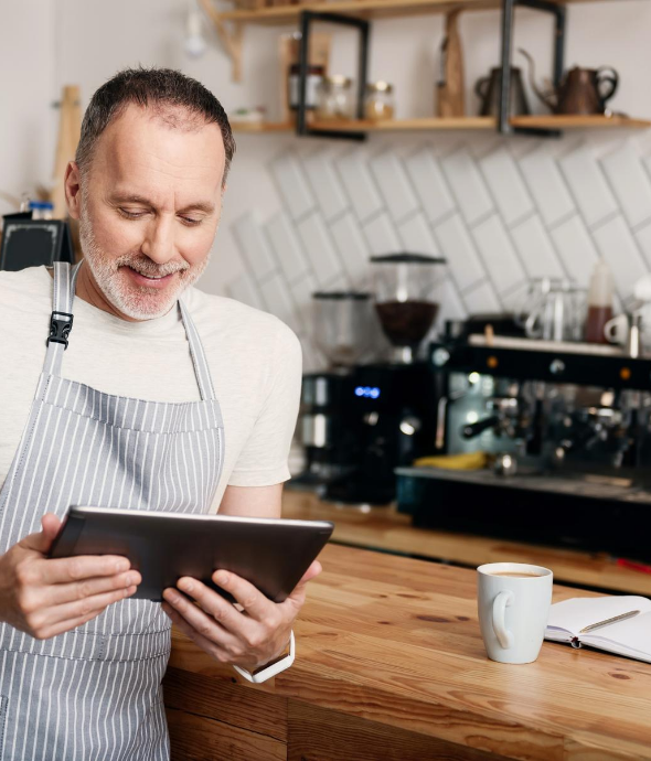 Barista looking at his energy usage on a tablet