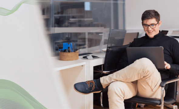 Man working in the office with a laptop on their lap