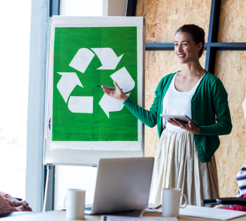 woman with board with recycling symbol in meeting