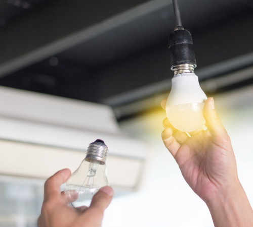 person changing light bulb to LED