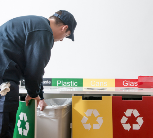 worker recycling with different colour bins