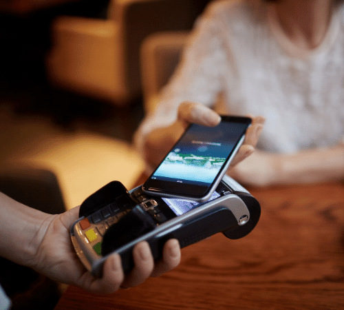 Woman paying on card machine with phone