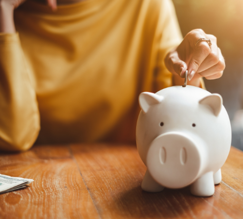 Person putting money into a piggybank 