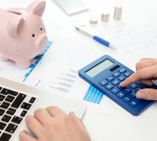 budgeting with calculator, sheets and piggy bank