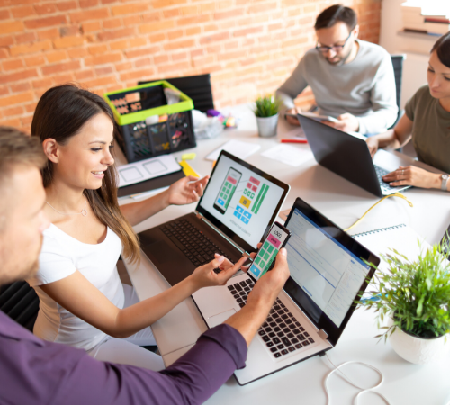 employees with laptops and phone collaborating with apps