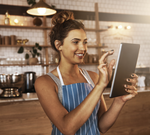 Coffee shop owner look at energy usage on a tablet