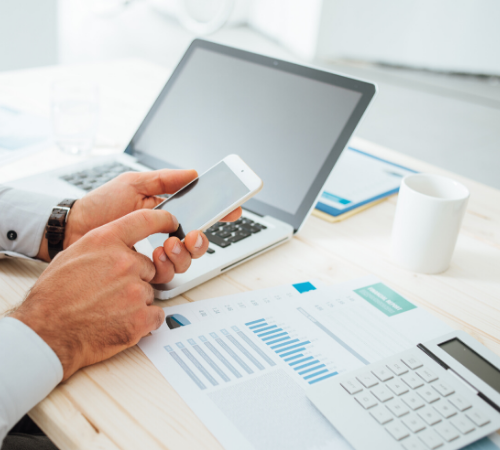 man on phone and laptop with financial spreadsheets and calculator