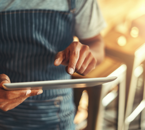 man using a tablet in coffee shop