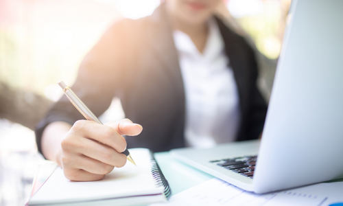 Person working and writing notes in notepad