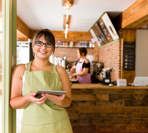 business owner in cafe holding tablet