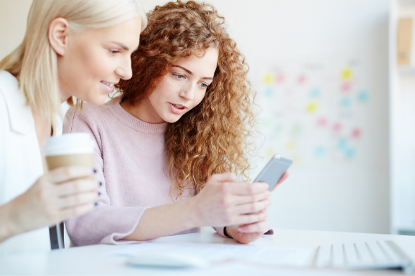 Two women using mobile phone for valda energy app