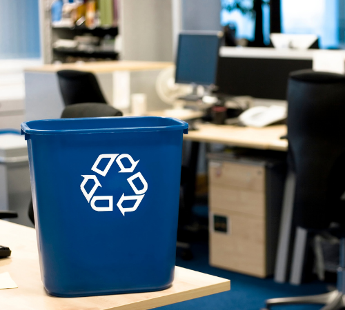 recycling bin by desks in office