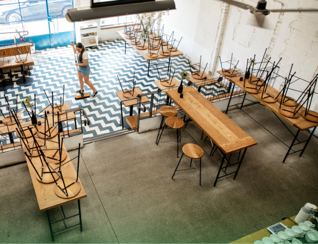 Staff cleaning floor of closed restaurant
