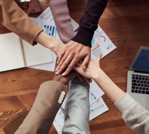 Business employees with hands joined together 