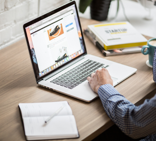 person on laptop with start up book