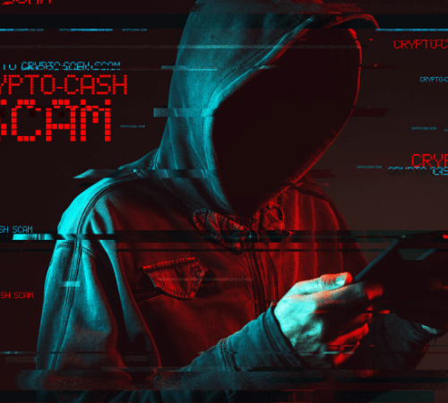 Hooded scammer on their mobile phone