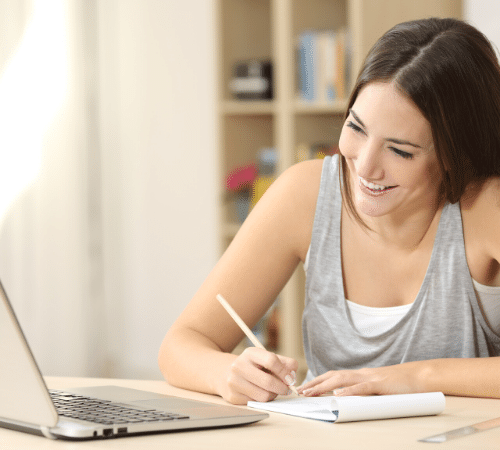Lady making notes whilst working from home