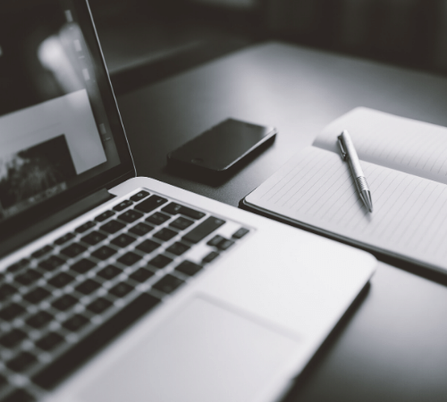 Laptop, phone and notepad on desk